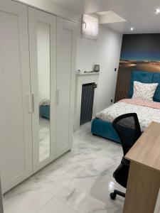 een slaapkamer met een bed, een bureau en een stoel bij Sahara & Joshua tree / calme & chaud in Montgeron