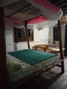 ein Schlafzimmer mit einem Himmelbett in der Unterkunft Mida Creek Eco Camp in Watamu