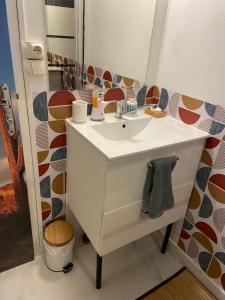 een badkamer met een witte wastafel en een spiegel bij Sahara & Joshua tree / calme & chaud in Montgeron