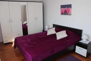 a bedroom with a purple bed with a purple blanket at Great apartment Katarina in Zadar