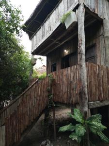 an old wooden house with a fence and a tree at Mida Creek Eco Camp in Watamu