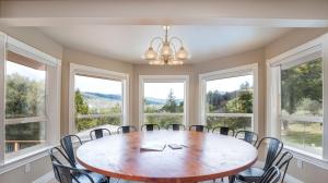 a dining room with a table and chairs and windows at Yosemite Adventure House with Pool-hot tub-game room in Oakhurst +55 photos