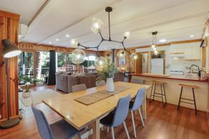 cocina y sala de estar con mesa de madera y sillas en Woodland Rise en Mount Buller