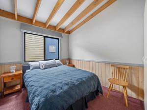 una camera con un letto e una sedia e una finestra di Disco 4 a Mount Buller
