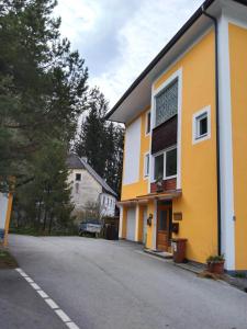 a yellow and white building on the side of a road at Appartement Rose in Liezen