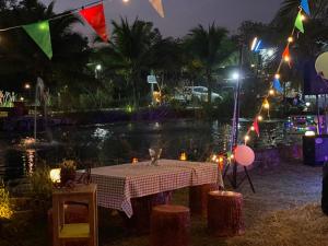 einen Tisch vor einem Teich in der Nacht in der Unterkunft Suan Nopparat in Suan Phung