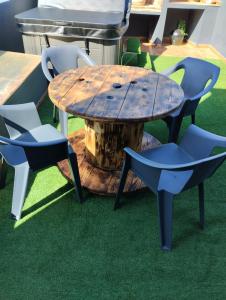 une table et des chaises en bois sur tapis vert dans l'établissement Casa vacacional Lavernia, à Cabanes