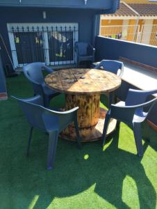 einen Tisch und Stühle auf einer Terrasse mit Gras in der Unterkunft Casa vacacional Lavernia in Cabanes