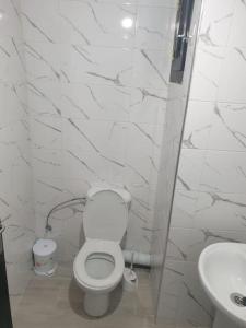a white bathroom with a toilet and a sink at Apartamento alhuceima in Al Hoceïma