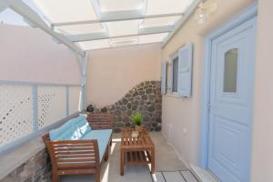 a balcony with a blue bench and a blue door at Sunrise Apartment Santorini in Emporio