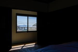una camera da letto con finestra con vista su un balcone di 島のまくら a Kure