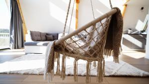 a hanging hammock in a living room with a couch at Cabanele A Frame, Salciua Noua in Sălciua Nouă