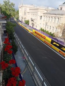 a train is traveling down a street with red flowers at Rotterdam in Baku