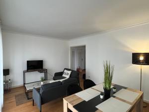 ein Wohnzimmer mit einem Sofa und einem Tisch in der Unterkunft Appartement T5 standing 104m2 in Orléans