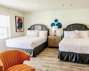 a bedroom with two beds and a chair in it at Saltwater 202 2nd Floor Low Tide in Surf City