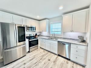 a kitchen with white cabinets and stainless steel appliances at Saltwater 202 2nd Floor Low Tide in Surf City