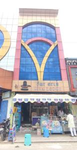 a man standing in front of a store in front of a building at SIVA LODGE in Rāmeswaram