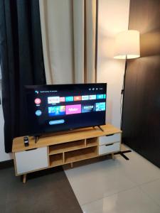 a flat screen tv sitting on top of a wooden entertainment center at Casa Antonio at Stamford McKinley Hill Unli Wi-Fi Near Piazza in Manila