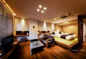 a hotel room with a bed and a living room at Hotel Oyanagi in Tagami