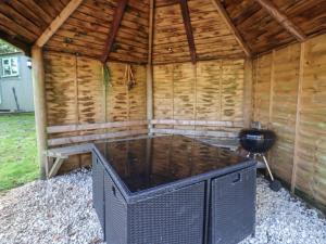 a large outdoor sauna with a grill in a wooden building at Elm 4 in Broadway