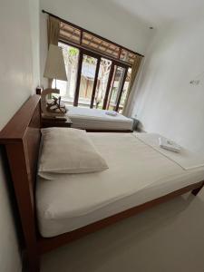 - 2 lits dans une chambre avec fenêtre dans l'établissement Sujana Homestay, à Ubud