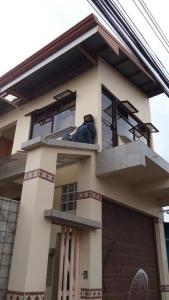 a man laying on a balcony of a house at Morada Kampos in Heredia