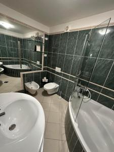 ein Badezimmer mit einem Waschbecken, einer Badewanne und einem WC in der Unterkunft First row to the sea - Maremi Izola Apartment terrace in Izola