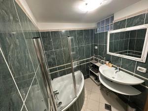 ein Badezimmer mit einer Dusche, einem Waschbecken und einer Badewanne in der Unterkunft First row to the sea - Maremi Izola Apartment terrace in Izola
