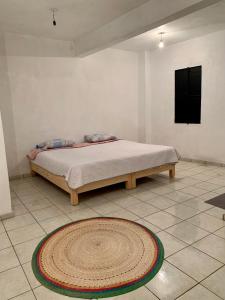 a bed in a room with a rug on the floor at Casa Mila in Taxco de Alarcón