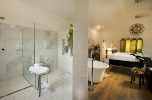 a bathroom with a tub and a bedroom with a bed at The Villa in Morpeth