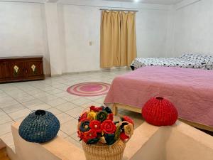 a bedroom with a bed and two baskets of flowers at Casa Mila in Taxco de Alarcón