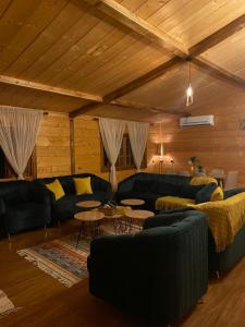 un soggiorno con divani e tavoli in una stanza di شاليةالخفجي a Al Khafji