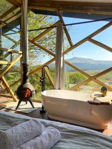 eine Badewanne in einem Zimmer mit Kamin in der Unterkunft Quaint Luxury Villas in Graskop