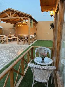eine Terrasse mit 2 Stühlen, einem Tisch und Tischen in der Unterkunft شاليةالخفجي in Al Khafji