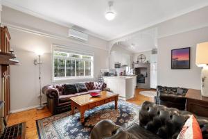 a living room with couches and a table at Currawong in Blackheath