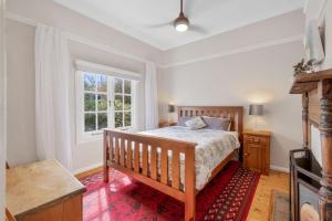 a bedroom with a bed and a window at Currawong in Blackheath