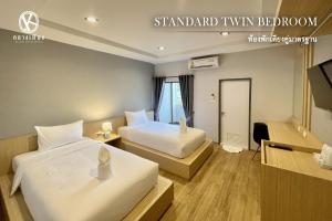 Postel nebo postele na pokoji v ubytování Klaang Muang Hotel (โรงแรมกลางเมือง)