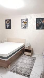 a bedroom with a bed and some pictures on the wall at Apartament TIMEEA Baile Herculane in Băile Herculane