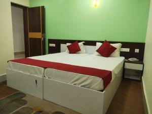 a bedroom with a large bed with red pillows at HOTEL SPACE SETTER in Bhubaneshwar