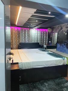 a large bed in a room with purple lighting at HOTEL SPACE SETTER in Bhubaneshwar