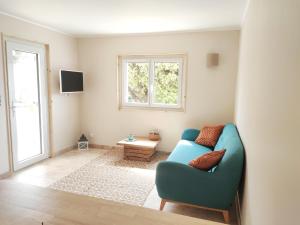 Au coin du Genévrier في Mollans-sur-Ouvèze: غرفة معيشة مع أريكة زرقاء ونافذة