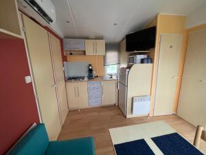a small room with a kitchen with a refrigerator at GRAIN DE SABLE - Mobil Home climatisé 5 pers - 100m de la mer - Le Portel in Le Portel