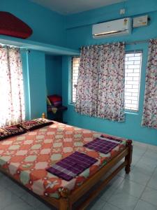 um quarto com uma cama com paredes e janelas azuis em Harbour town holiday home -malpe em Malpe