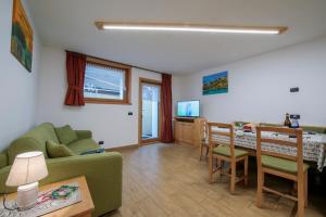 een woonkamer met een groene bank en een tafel bij Volga Loira Senna - Happy Rentals in Livigno