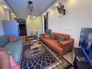 een woonkamer met 2 banken en een tafel bij جراند هيلز الساحل الشمالي مدينه الحمام الكيلو 60 in Abû Zeira