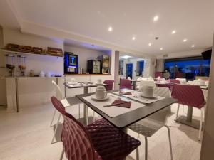 - une salle à manger avec une table et des chaises dans l'établissement Cit'Hotel Les Atlantes, à Médis
