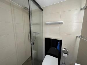 uma casa de banho com um WC e uma cabina de duche em vidro. em Jonnys Paradisli em Reams