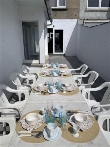 a long table with plates and cups and dishes on it at Raversea op enkele minuten wandelen van de zee. in Ostend