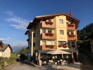 un edificio con mesas y sillas delante de él en Hotel Schölzhorn Superior en Racines