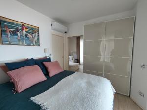 een slaapkamer met een groot bed met roze en blauwe kussens bij Fabula Home Rental - Blue Note in Solto Collina
